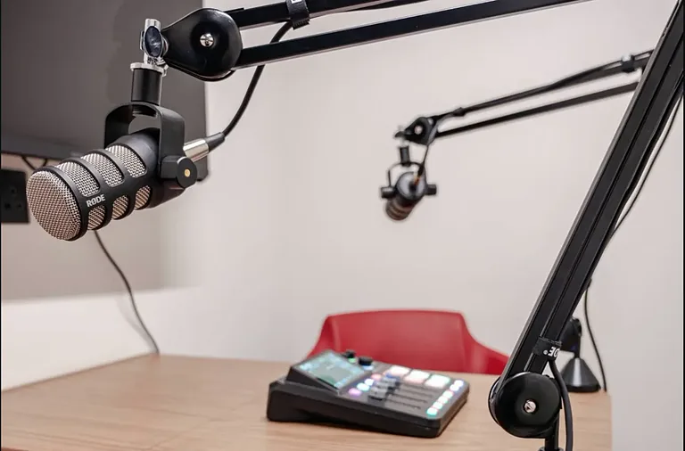 Podcast microphones on boom arms and a mixing desk in the Apex Coworking podcast studio