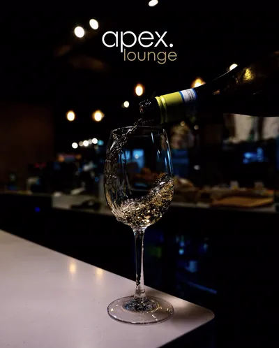 White wine being poured into a glass at the Apex Lounge bar